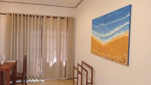 a dining room with a table and a painting on the wall at Hiri Point Villa in Dickwella +26 photos