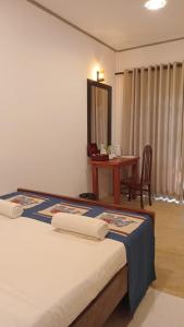 a bedroom with a bed with a table and a mirror at Hiri Point Villa in Dickwella