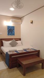a bedroom with a bed with a table in it at Hiri Point Villa in Dickwella
