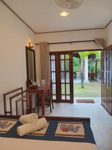 a room with a table and a bed with towels on it at Hiri Point Villa in Dickwella