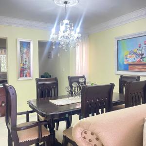 a dining room with a table and chairs and a chandelier at Confortable in San Isidro +1 photo