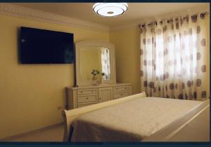 a bedroom with a bed and a dresser with a television at Confortable in San Isidro