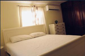 a bedroom with a white bed and a window at Confortable in San Isidro