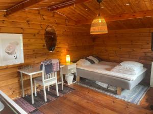 a bedroom with a bed and a desk in a cabin at Solberga red cottage in Solberga
