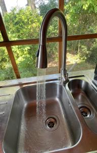 a kitchen sink with water coming out of a faucet at Solberga red cottage in Solberga