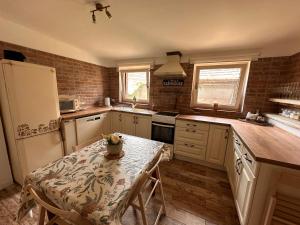 a kitchen with a table and a refrigerator and a counter at Ubytovanie Lišov 3 - Vidiecky dom in Lišov +9 photos