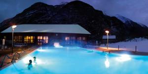 a building with blue lights in front of a mountain at Casa Fattorini in Baceno