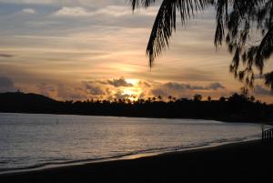 a sunset over a body of water with trees at Fajardo Peaceful Place in Playa Sardinera +21 photos