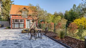 a patio with a table and chairs in a garden at Les Cognassiers - Studio Cosy & Equipé - Parking Gratuit - Professionnels & Familles in Illkirch-Graffenstaden