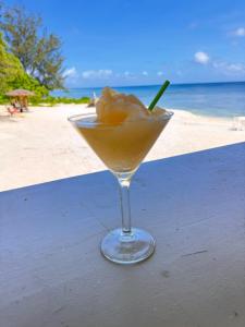 a drink sitting on a table next to the beach at Coco Beach Resort in Port Vila