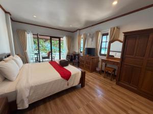 a bedroom with a bed and a desk and a television at Chaweng Bliss Bungalow in Chaweng