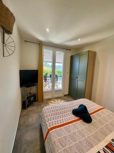 a bedroom with a bed and a flat screen tv at Au cocon du verdon, T2 in Gréoux-les-Bains