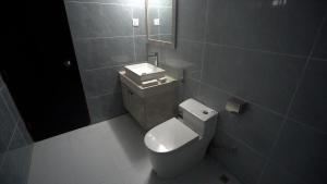 a bathroom with a toilet and a sink and a mirror at The Swiss Hotel & Resort in Cox's Bazar
