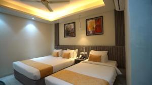 two beds in a hotel room with two beds sidx sidx sidx at The Swiss Hotel & Resort in Cox's Bazar