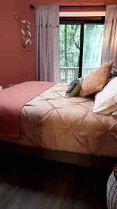 a bedroom with a bed with pillows and a window at Rustic Tree Top Cabin in Sky Valley, Georgia in Sky Valley +23 photos