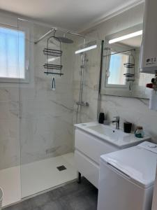 a white bathroom with a shower and a sink at Au cocon du verdon, T2 in Gréoux-les-Bains