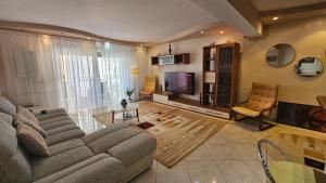 a living room with a couch and a television at Eva apartments in Mamaia