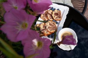 a plate of pastries and a cup of coffee and purple flowers at ELITEO GUESTHOUSE Dabuleni in Dăbuleni +24 photos