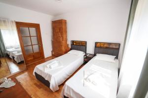 a bedroom with two beds and a mirror at ELITEO GUESTHOUSE Dabuleni in Dăbuleni