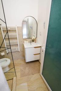 a bathroom with a sink and a mirror and a toilet at ELITEO GUESTHOUSE Dabuleni in Dăbuleni
