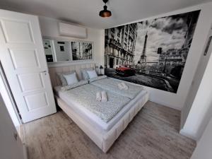 a bedroom with a bed with a large picture on the wall at Kúria Apartman Extra in Budapest +44 photos