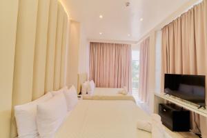 a hotel room with two beds and a flat screen tv at Pitstop Mango Grove Retreat in Guimaras