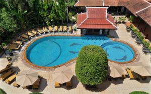 an overhead view of a swimming pool with chairs and umbrellas at The Heritage Courtyard in Siem Reap +65 photos