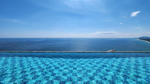 an empty swimming pool with a view of the ocean at Gangneung Chonpines Ocean Suites Hotel in Gangneung