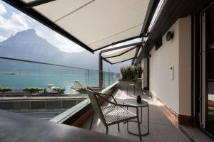 a balcony with a chair and a view of the ocean at Hotel Safiro in Fluelen