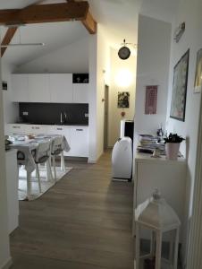 a kitchen and dining room with white cabinets and a table at B&B Elisè in Castel Ivano