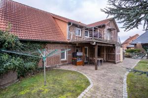 a brick house with a balcony and a patio at Ferienapartment 2 Heimathafen in Seedorf