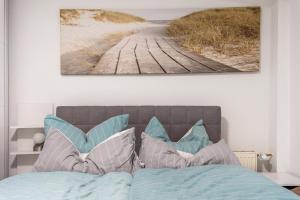 a bedroom with a bed with a picture on the wall at Ferienapartment 2 Heimathafen in Seedorf