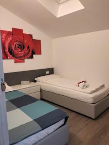 a room with two beds and a painting on the wall at B&B Elisè in Castel Ivano
