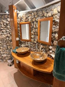 a stone bathroom with two sinks and two mirrors at Coco Beach Resort in Port Vila