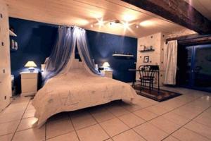 a bedroom with a large bed with blue walls at Chambre d'Hôte La Boulière in Martigné-Ferchaud