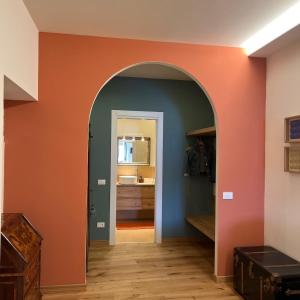an archway in a room with an orange wall at SAGGEZZA Villa di GARGNANO in Gargnano
