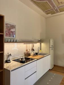 a kitchen with white cabinets and a stove top oven at SAGGEZZA Villa di GARGNANO in Gargnano +5 photos