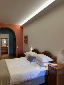 a bedroom with a bed with white sheets and pillows at SAGGEZZA Villa di GARGNANO in Gargnano