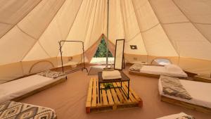 a tent with four beds and a table in it at Villa Verde in Perquín
