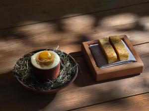 a table with a plate of eggs and some bread at Prosilio olive tree houses in Tsilivi