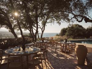 a group of tables and chairs next to a pool at Prosilio olive tree houses in Tsilivi