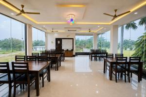 a conference room with tables and chairs and a screen at Takery Resort in Chittaurgarh