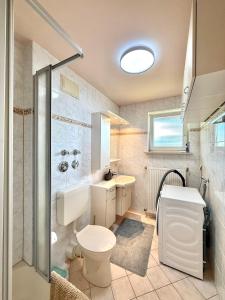a bathroom with a toilet and a sink and a shower at Zuhause am Kurgarten in Bad Reichenhall +35 photos