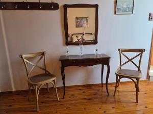 a table with two chairs and a mirror on a wall at Arhodico Simou mansion in Kambos