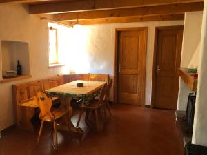 ein Esszimmer mit einem Holztisch und Stühlen in der Unterkunft Rustico Scoperta in Linescio + 7 Fotos