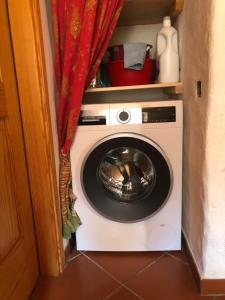 eine Waschmaschine in einem Zimmer mit einem roten Vorhang in der Unterkunft Rustico Scoperta in Linescio