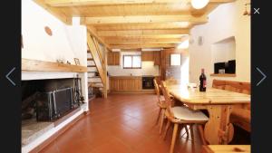 Eine Küche und ein Esszimmer mit Tisch und Kamin in der Unterkunft Rustico Scoperta in Linescio