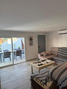 a living room with a couch and a table at Villa Alhamar con piscina climatizada privada in Punta Umbría