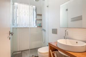 a bathroom with a sink and a toilet and a shower at Spetses Estia Orloff in Spetses +25 photos
