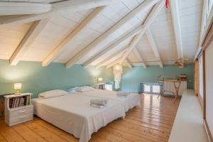 a bedroom with two beds and a wooden floor at Spetses Estia Orloff in Spetses
